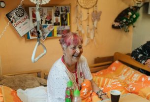 Cheerful elderly women sharing a light moment in a cozy hospital room.